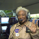 Nichelle Nichols in a NASA flight suit doing the Vulcan salute